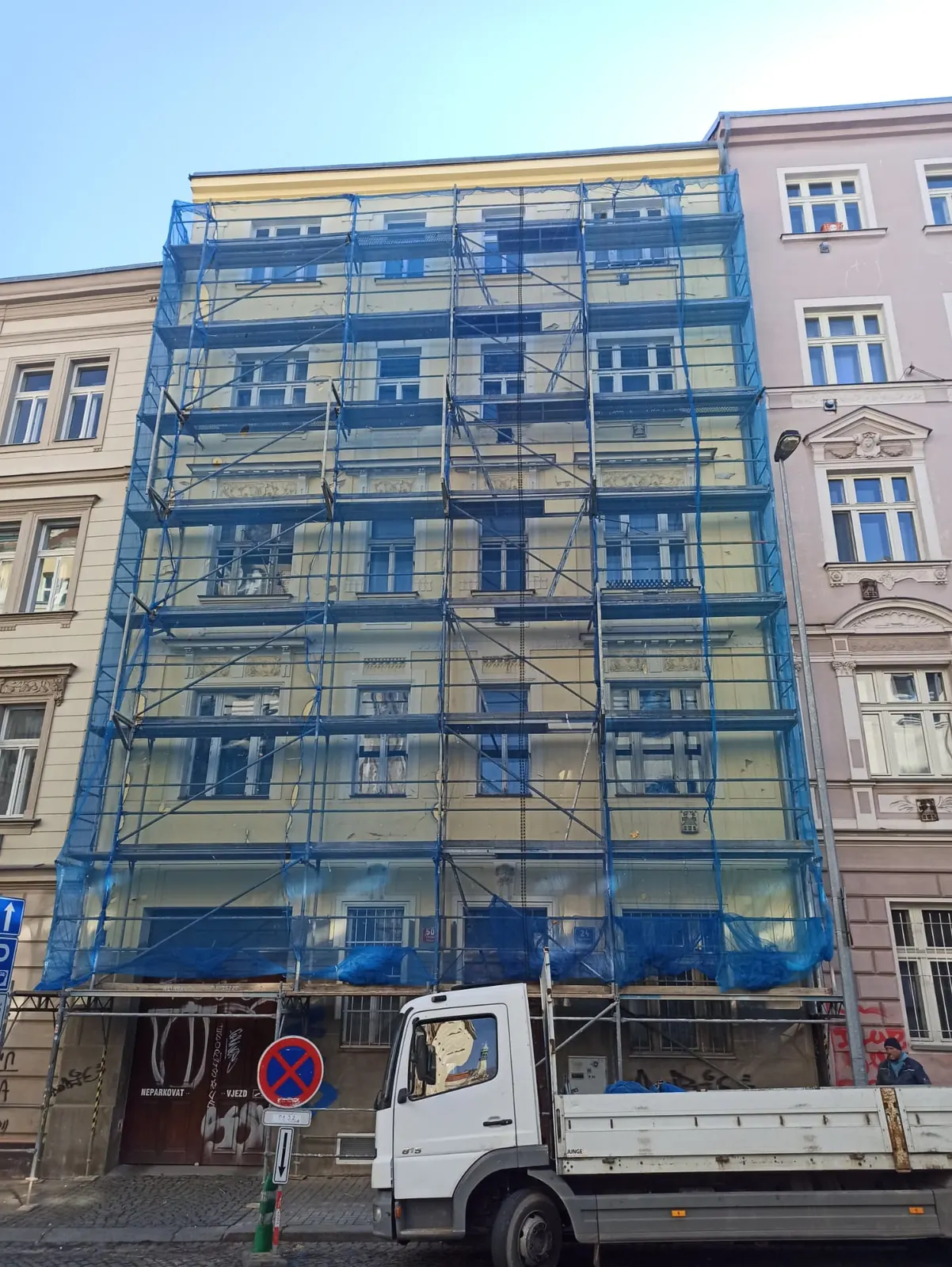Fasádní lešení s ochrannou sítí na bytovém domě v Praze